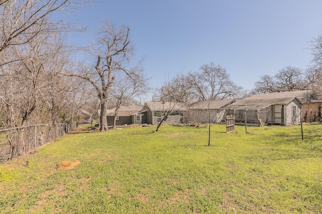 view of yard with a storage shed, an outdoor structure, and fence