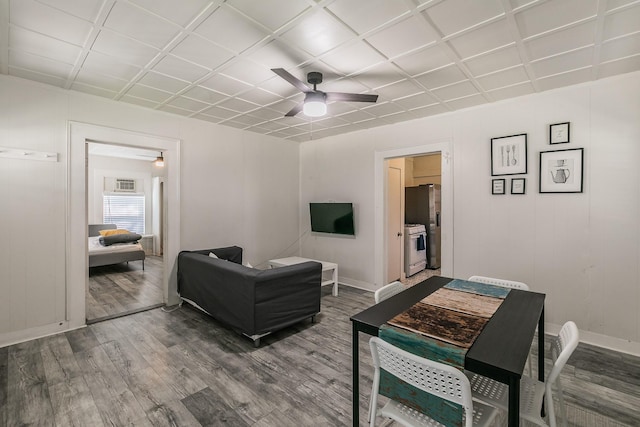 living area featuring baseboards, wood finished floors, and a ceiling fan