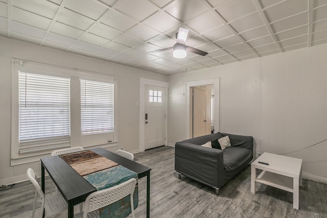 living area featuring baseboards, wood finished floors, and a ceiling fan