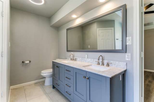 bathroom with tile patterned floors, double vanity, baseboards, and a sink