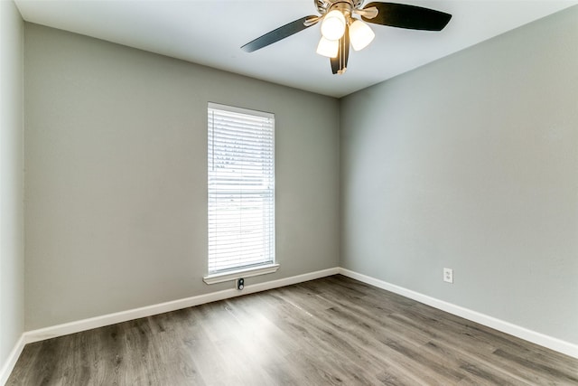 spare room featuring a ceiling fan, baseboards, and wood finished floors