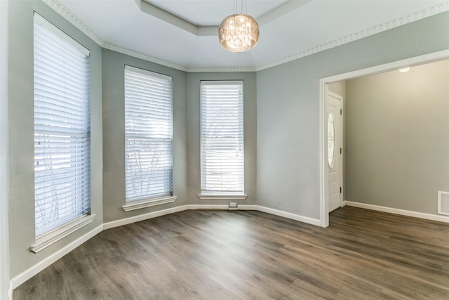 unfurnished room featuring wood finished floors, baseboards, visible vents, a tray ceiling, and a notable chandelier