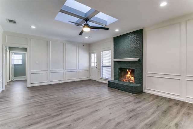 unfurnished living room with a decorative wall, a skylight, and visible vents