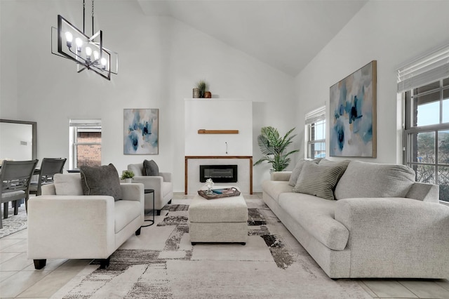 1121 Basswood Ln, Royse City, TX 75189 - living room with a chandelier, a glass covered fireplace, tile patterned flooring, and high vaulted ceiling