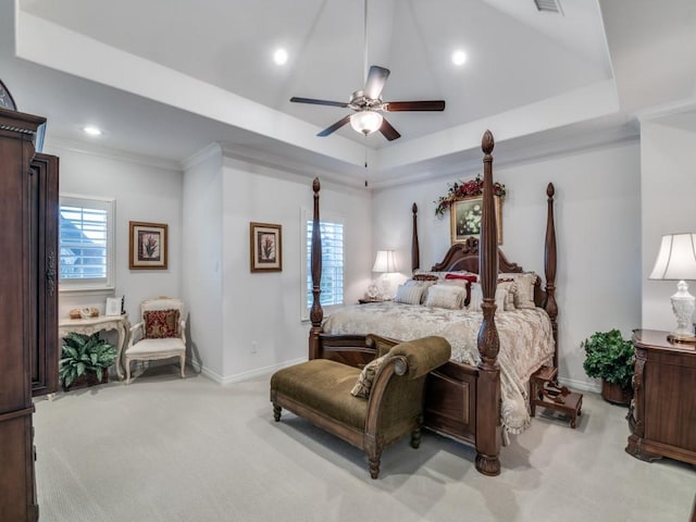 bedroom featuring visible vents, light carpet, a raised ceiling, a ceiling fan, and baseboards