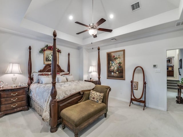 bedroom with baseboards, visible vents, ceiling fan, light carpet, and a raised ceiling