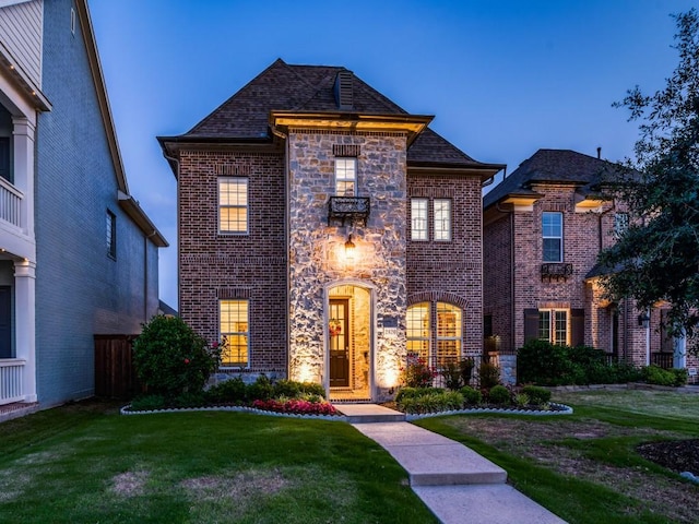 view of front of house featuring a front yard and brick siding