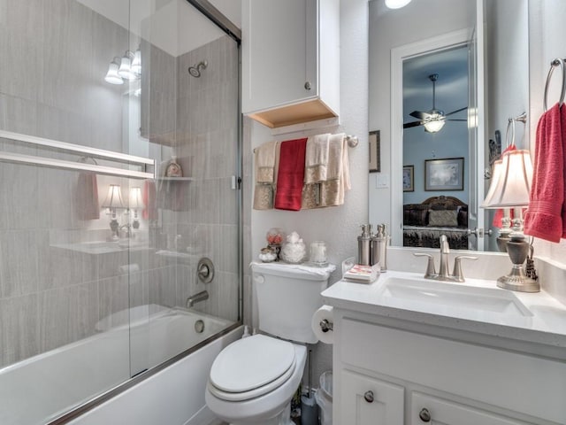 ensuite bathroom with toilet, ensuite bathroom, a ceiling fan, shower / bath combination with glass door, and vanity