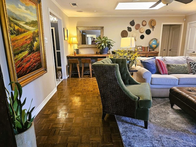 living room featuring a ceiling fan, baseboards, visible vents, a skylight, and ornamental molding