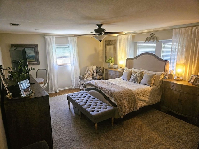 bedroom with a ceiling fan, visible vents, and a textured ceiling