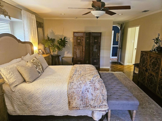 bedroom with crown molding, a ceiling fan, visible vents, and baseboards