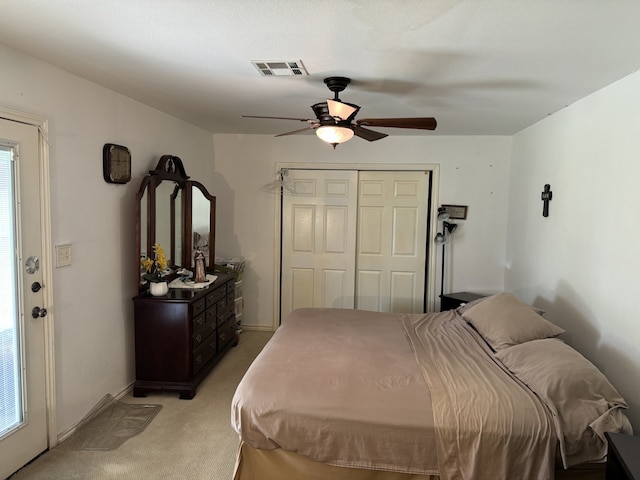 bedroom featuring a closet, light carpet, baseboards, visible vents, and a ceiling fan
