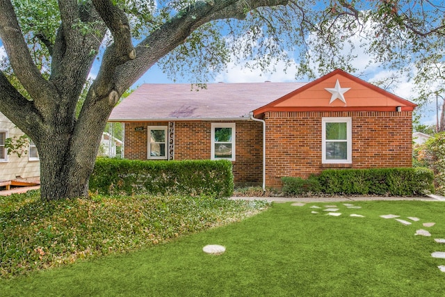ranch-style house with a front lawn and brick siding