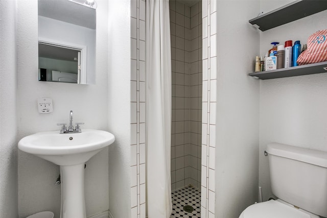 bathroom featuring toilet and a stall shower