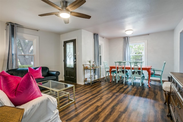 living room with a textured ceiling, baseboards, a ceiling fan, and wood finished floors