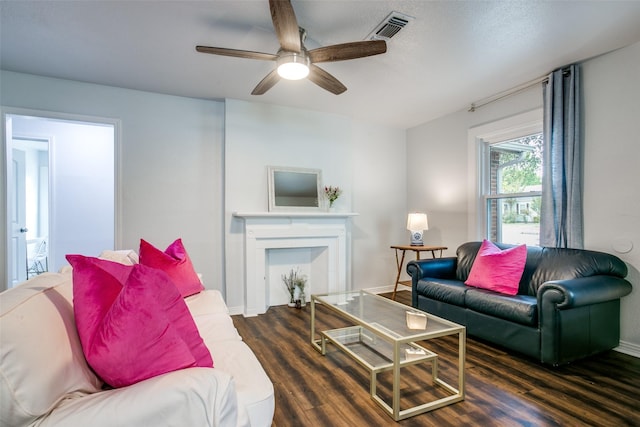 living room with visible vents, baseboards, wood finished floors, and a ceiling fan