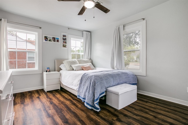 bedroom featuring multiple windows, dark wood-style floors, and baseboards