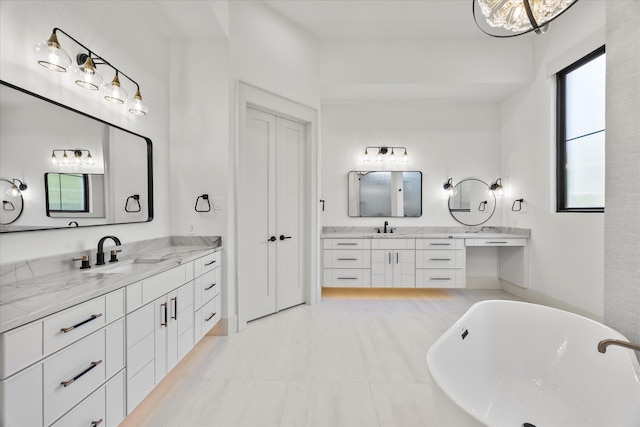 full bath with a soaking tub, two vanities, and a sink
