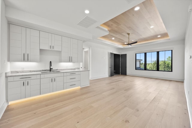 kitchen featuring a tray ceiling, white cabinetry, visible vents, recessed lighting, and light wood finished floors