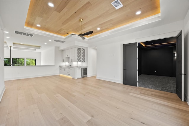 unfurnished living room featuring visible vents, a raised ceiling, and wooden ceiling