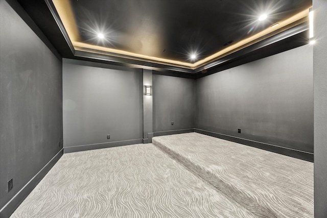 carpeted empty room featuring a tray ceiling, baseboards, and recessed lighting
