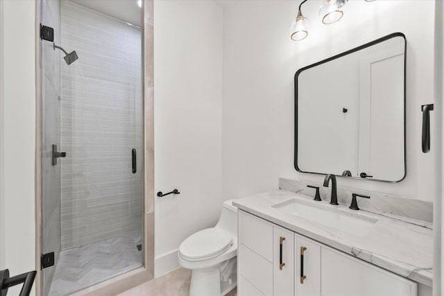 bathroom featuring a shower stall, vanity, and toilet