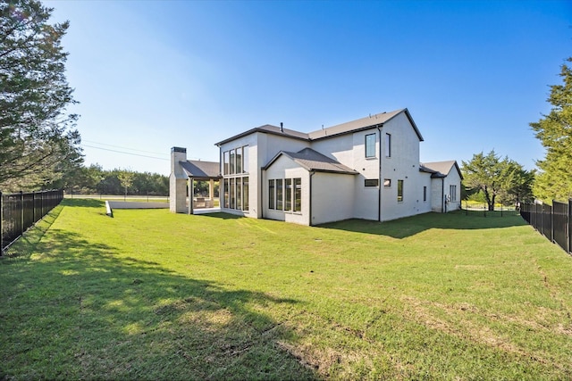 back of house featuring a yard, a fenced backyard, and stucco siding
