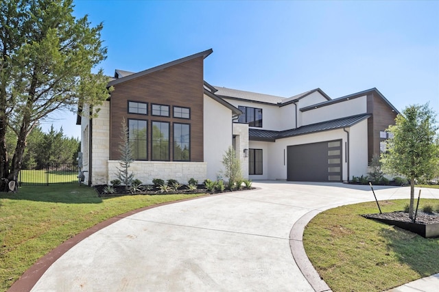 modern home featuring a front yard, a standing seam roof, metal roof, fence, and driveway