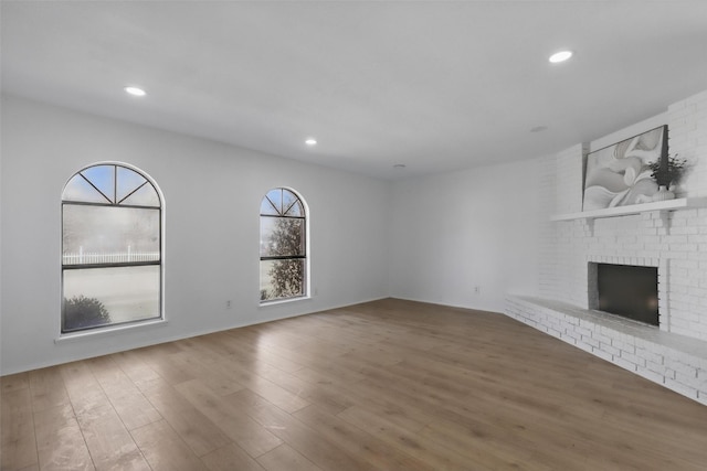 1329 Steinburg Ln, Fort Worth, TX 76134 - unfurnished living room featuring wood finished floors, a brick fireplace, and recessed lighting