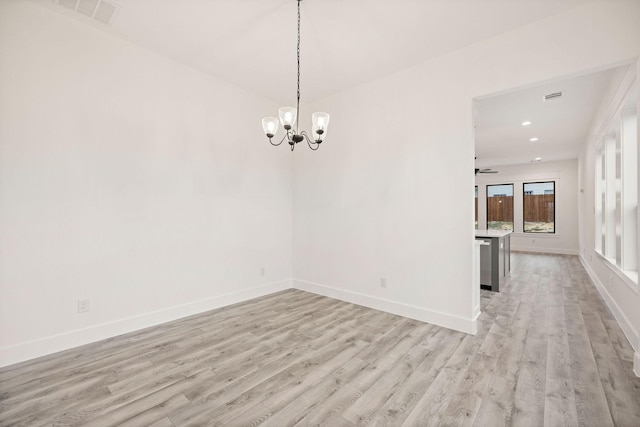 spare room featuring light wood-type flooring, visible vents, recessed lighting, an inviting chandelier, and baseboards