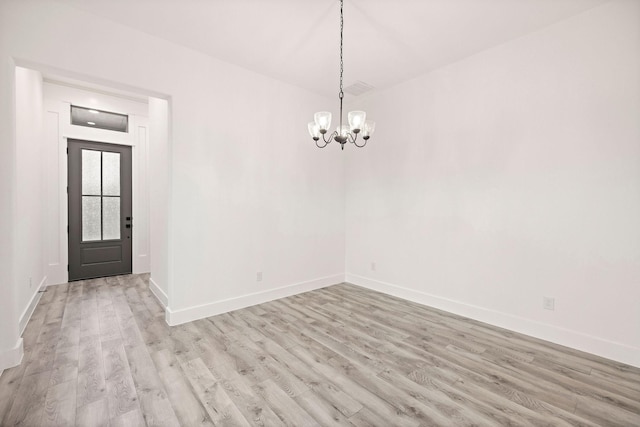 unfurnished dining area with baseboards, light wood-style floors, and an inviting chandelier