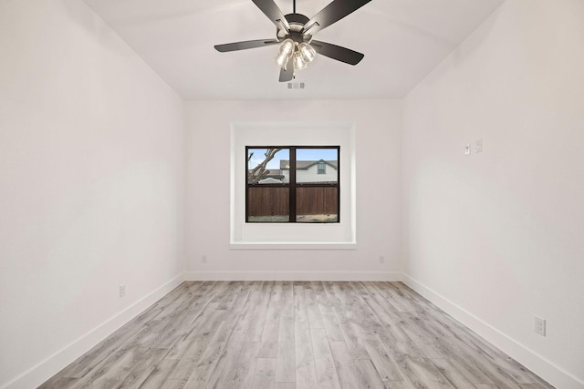 unfurnished room featuring baseboards, visible vents, light wood finished floors, and ceiling fan