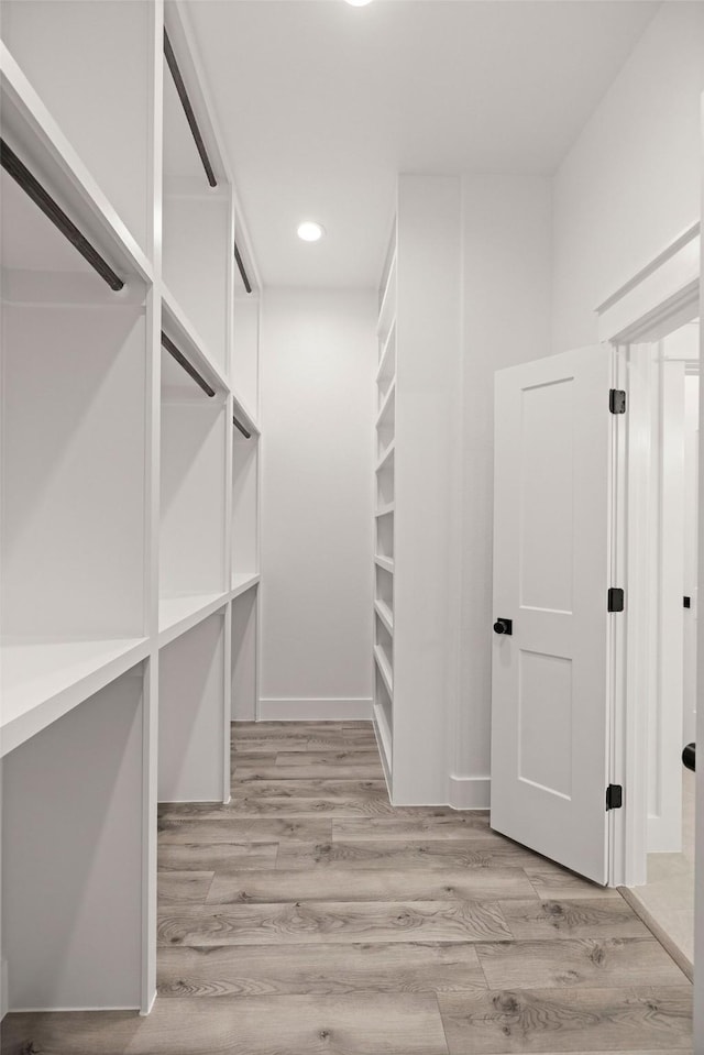 walk in closet with light wood-type flooring