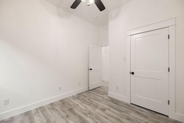 unfurnished bedroom featuring light wood finished floors, a ceiling fan, and baseboards