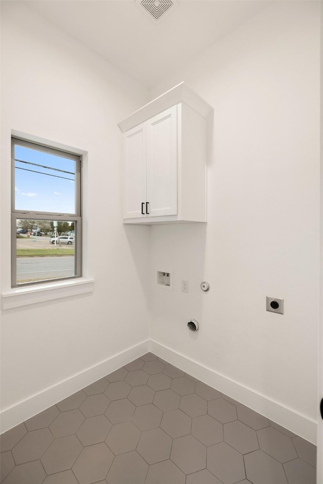 clothes washing area featuring baseboards, visible vents, cabinet space, electric dryer hookup, and hookup for a gas dryer