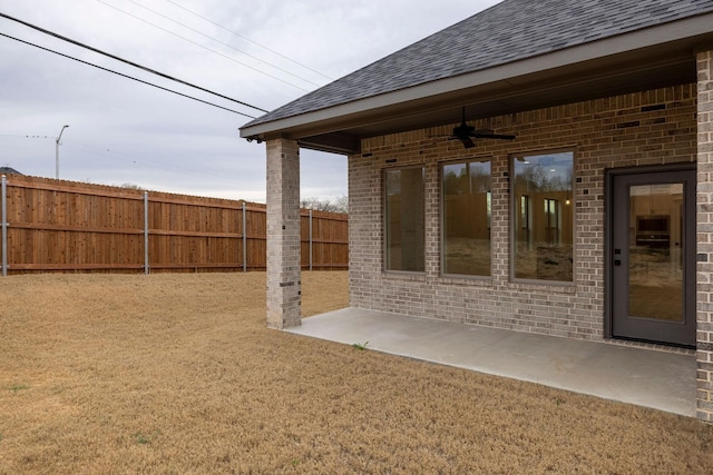 view of yard with a patio area, a ceiling fan, and fence
