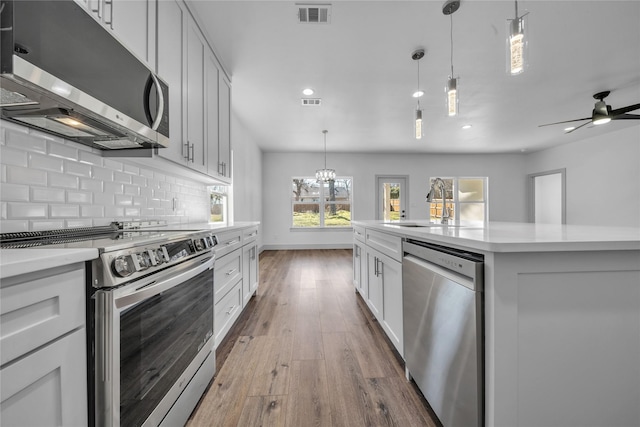 2408 Givendale Rd, Dallas, TX 75241 - kitchen with stainless steel appliances, light countertops, recessed lighting, wood finished floors, and backsplash