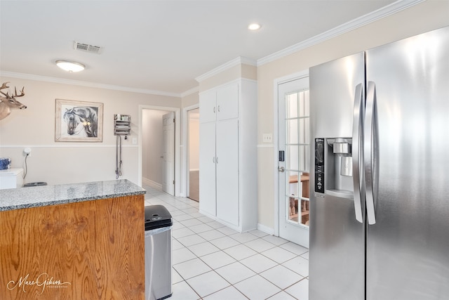 kitchen featuring visible vents, ornamental molding, stainless steel refrigerator with ice dispenser, light stone counters, and light tile patterned flooring