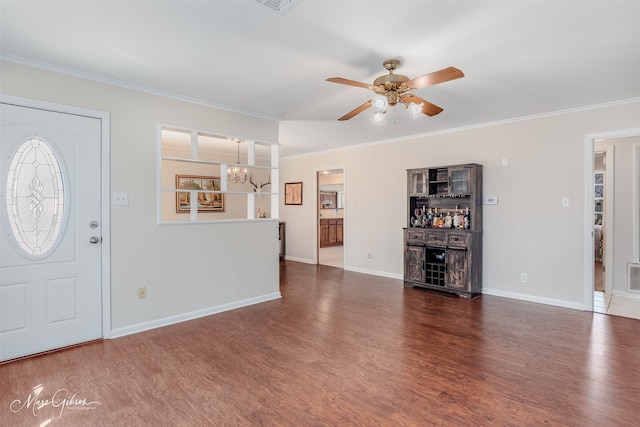 foyer entrance featuring ornamental molding, ceiling fan with notable chandelier, and wood finished floors