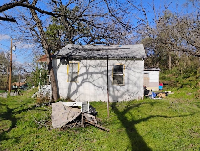 view of side of home with a lawn and an outdoor structure