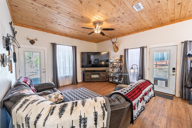 living room with wood ceiling, wood finished floors, visible vents, and ceiling fan