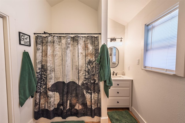 full bathroom featuring vanity, lofted ceiling, and a shower with shower curtain