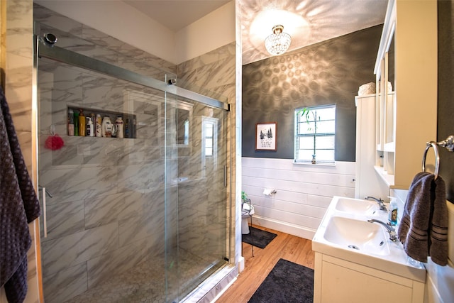 full bathroom featuring wood finished floors, a stall shower, and a sink