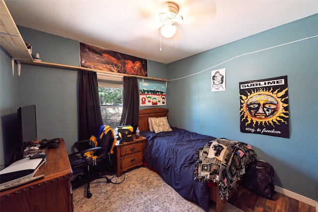 bedroom with wood finished floors, a ceiling fan, and baseboards