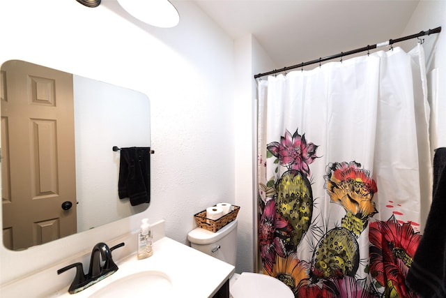 bathroom with vanity, a shower with shower curtain, and toilet