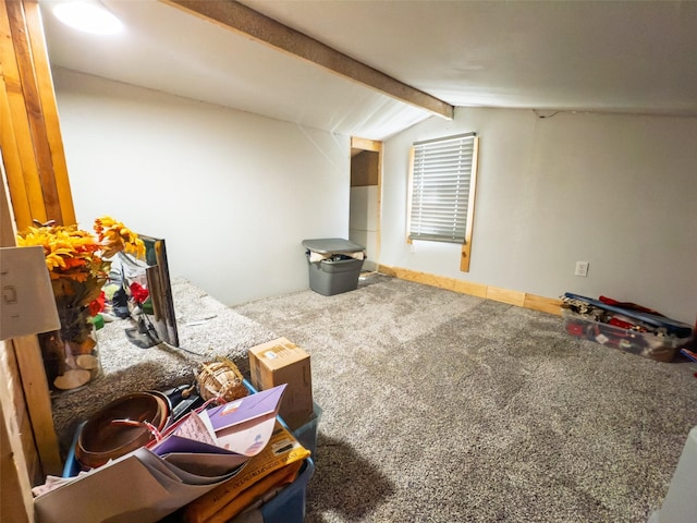 carpeted living room featuring lofted ceiling with beams