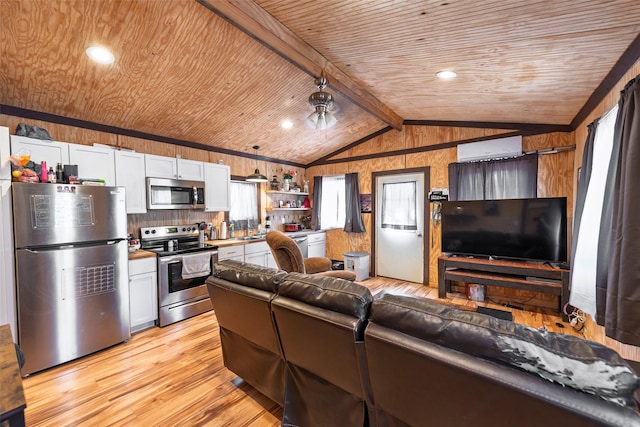 kitchen with vaulted ceiling with beams, open floor plan, wooden ceiling, light wood-style floors, and stainless steel appliances