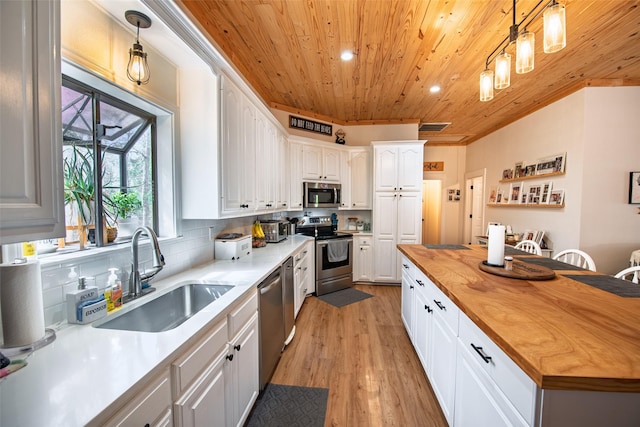 kitchen with backsplash, wood ceiling, stainless steel appliances, wood counters, and a sink