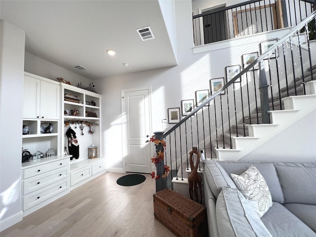 mudroom featuring visible vents, baseboards, and wood finished floors