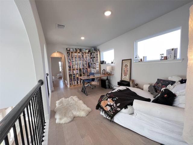 bedroom featuring visible vents, recessed lighting, wood finished floors, and arched walkways